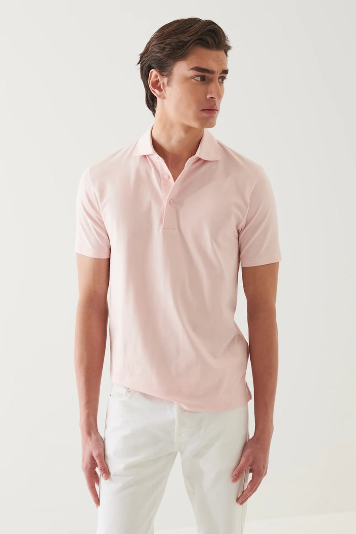 Homme portant un polo à manches courtes roses, style épuré, confort doux et respirant.