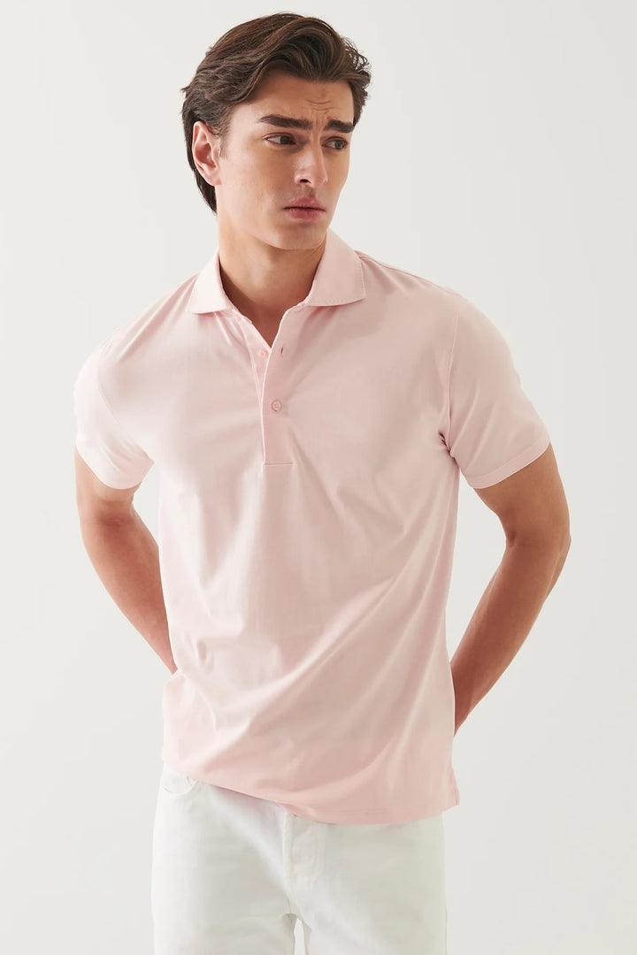 Homme portant un polo à manches courtes rose, au design épuré et confortable, idéal pour un style chic et décontracté.