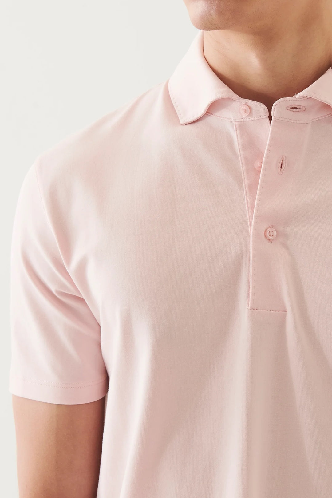 Polo à manches courtes en rose, tissu doux, col classique et patte de boutonnage à deux boutons, style décontracté.