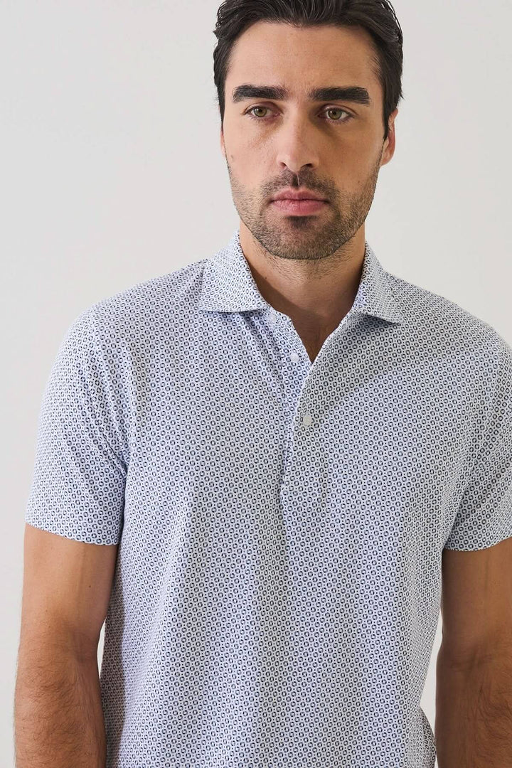 Homme portant un POLO IMPRIMÉ À MANCHES COURTES avec un motif géométrique discret et un col ouvert, idéal pour l&