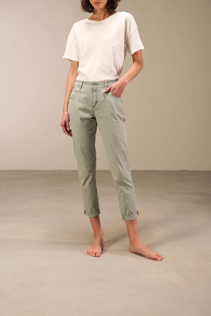 Pantalon 7/8 moulant à taille basse en coton bio, avec ourlet retroussé et bandes décoratives, couleur vert pâle.