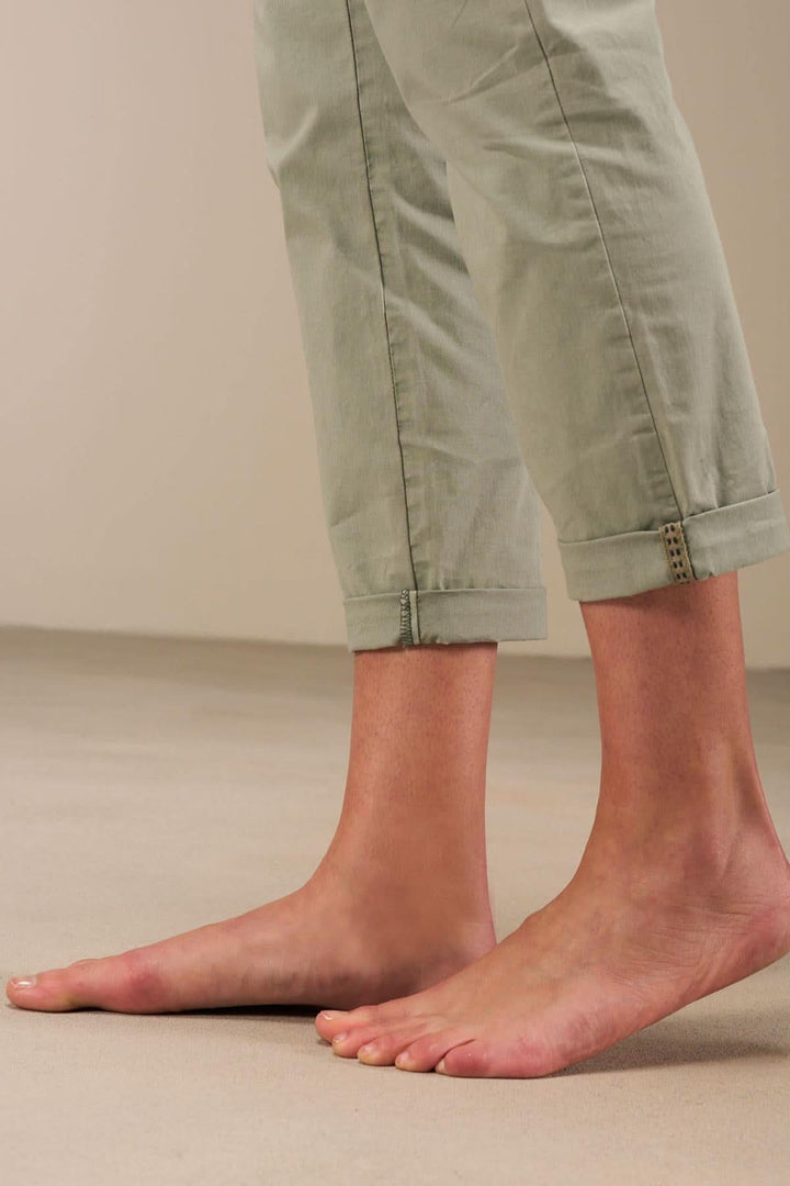 Pantalon 7/8 moulant à taille basse, ourlet retroussé et bandes décoratives, couleur verte.