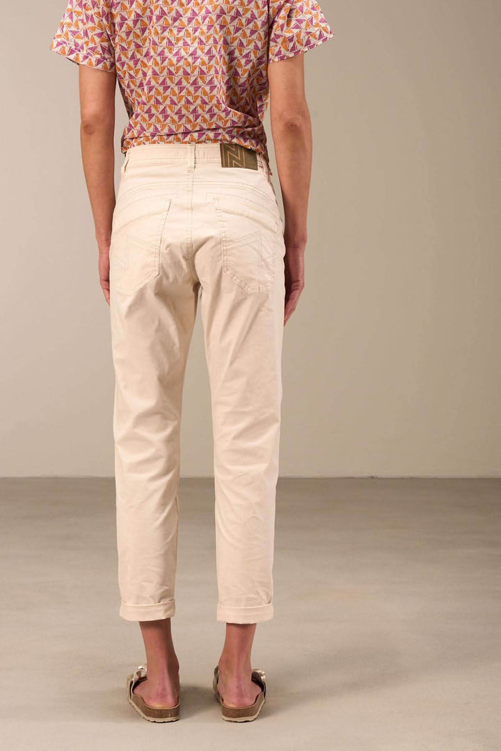 Pantalon 7/8 moulant beige avec ourlet retroussé, vue arrière, porté sur un dos féminin.