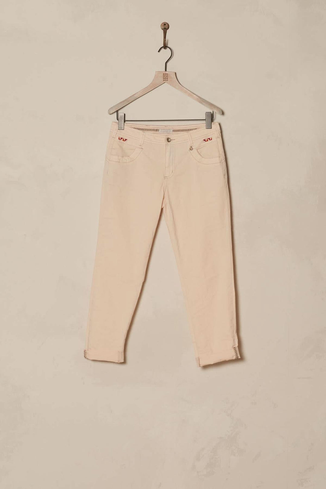 Pantalon 7/8 moulant en coton bio, teinte claire avec ourlet retroussé et bandes décoratives sur la couture intérieure.