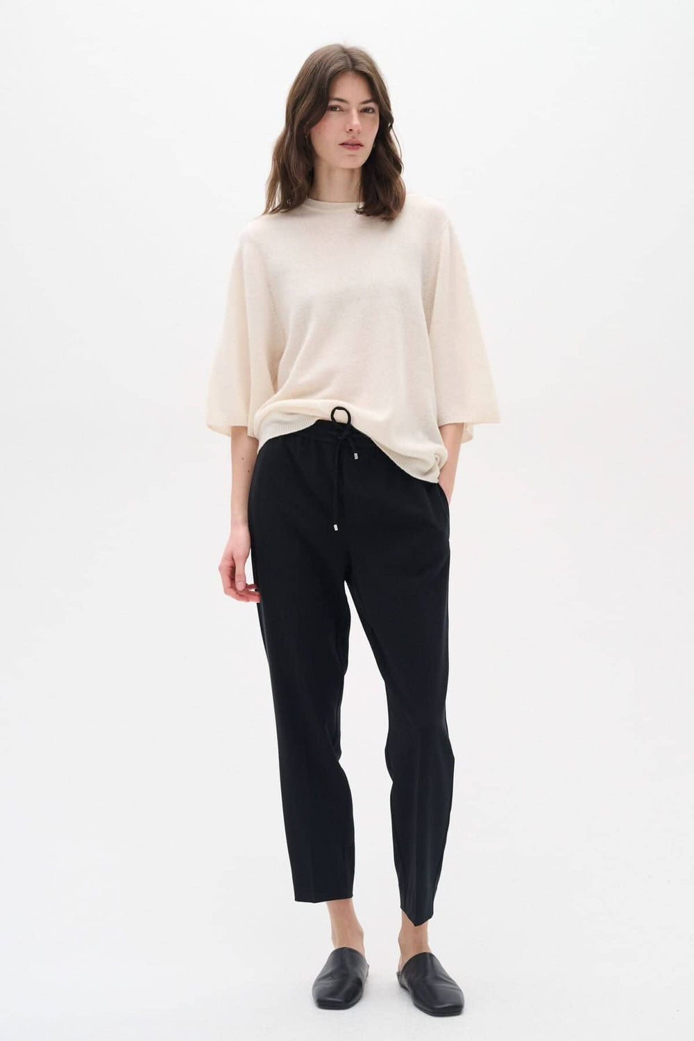 Femme portant le pantalon Adian avec un haut beige, offrant un look chic et décontracté.