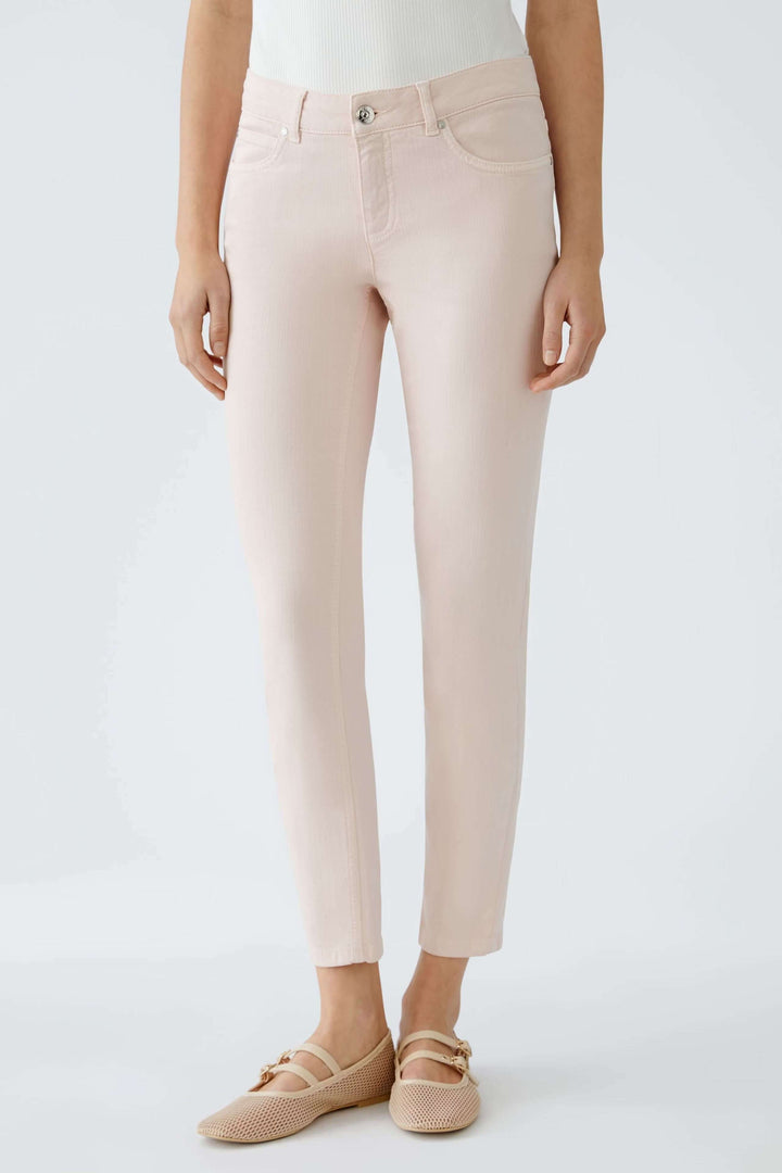 Pantalon Baxtor slim rose à taille mi-haute, longueur raccourcie, porté avec des chaussures confortables.