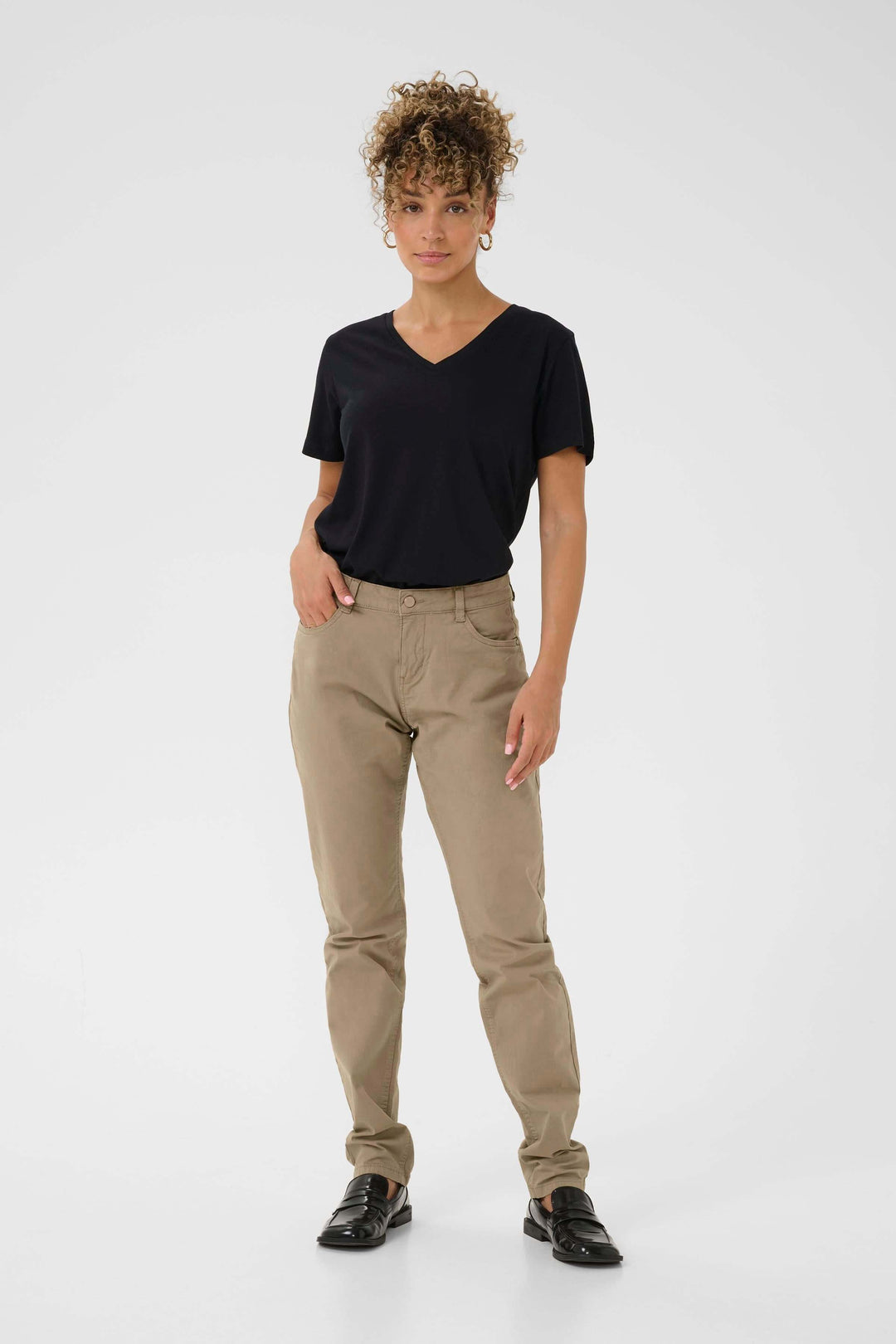 Femme en pantalon Berta beige avec t-shirt noir, look décontracté et chic, style moderne et soigné.