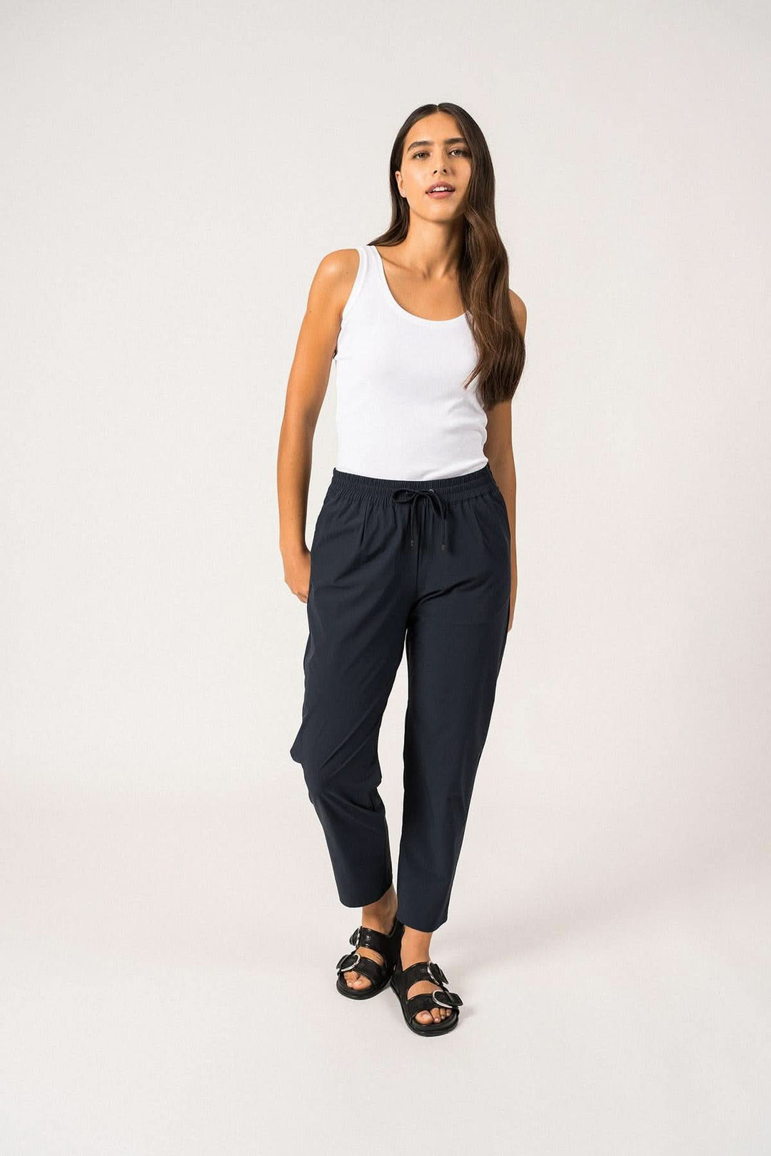 Femme en pantalon DEBORAH léger et technique avec taille élastique, t-shirt basique et sandales.