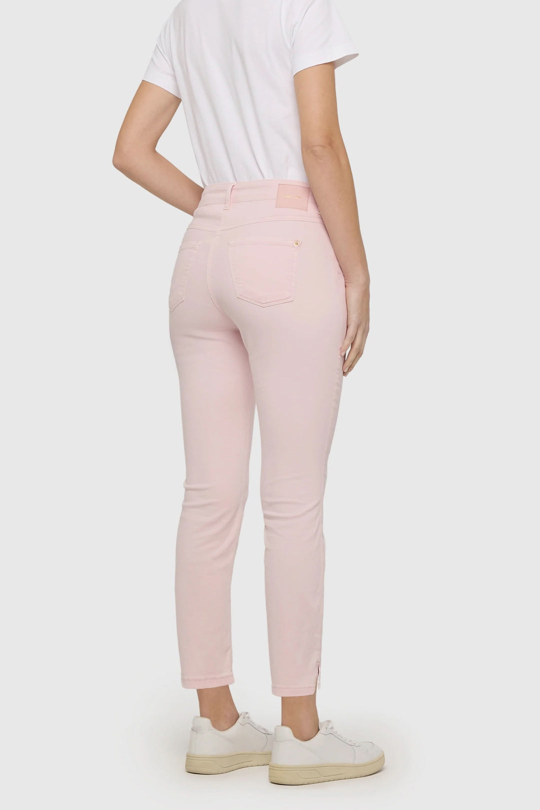 Person wearing Pantalon Dream Summer, pink skinny fit pants, shown from the back, paired with a white t-shirt and sneakers.