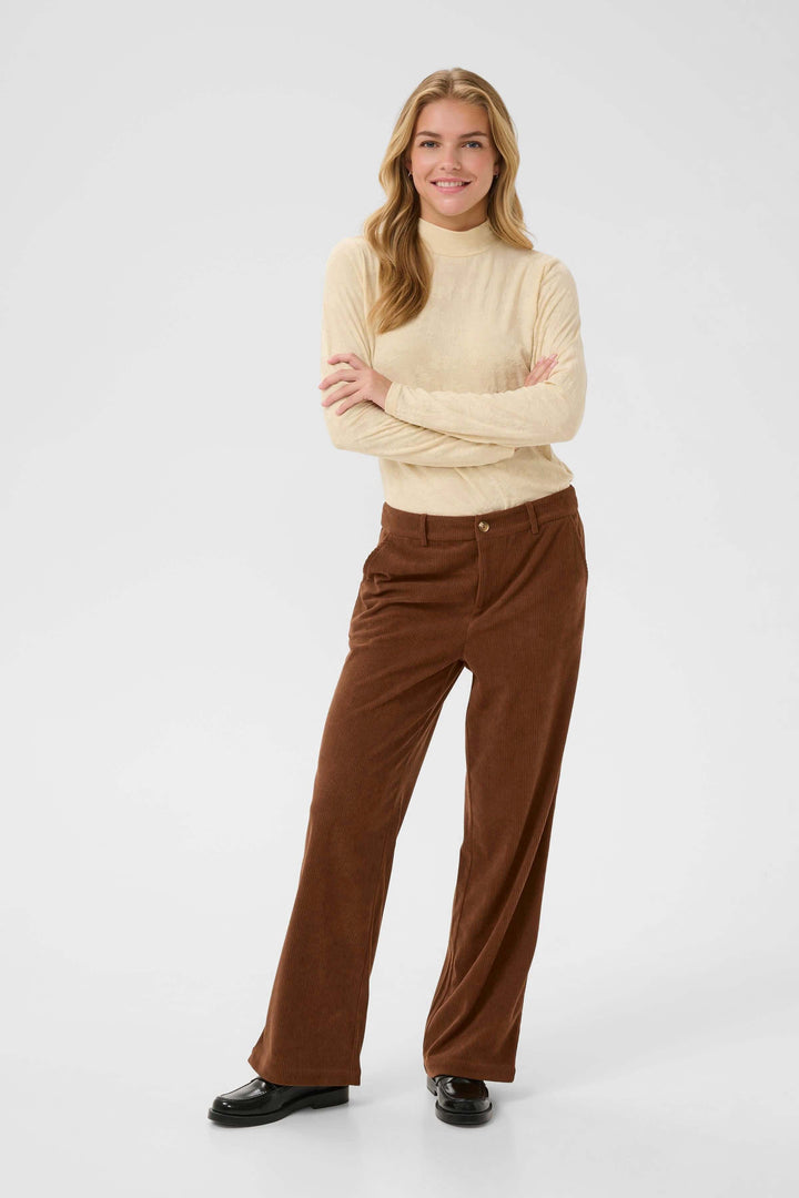 Femme portant le Pantalon Kanna en velours côtelé à jambe large marron, style élégant et décontracté.