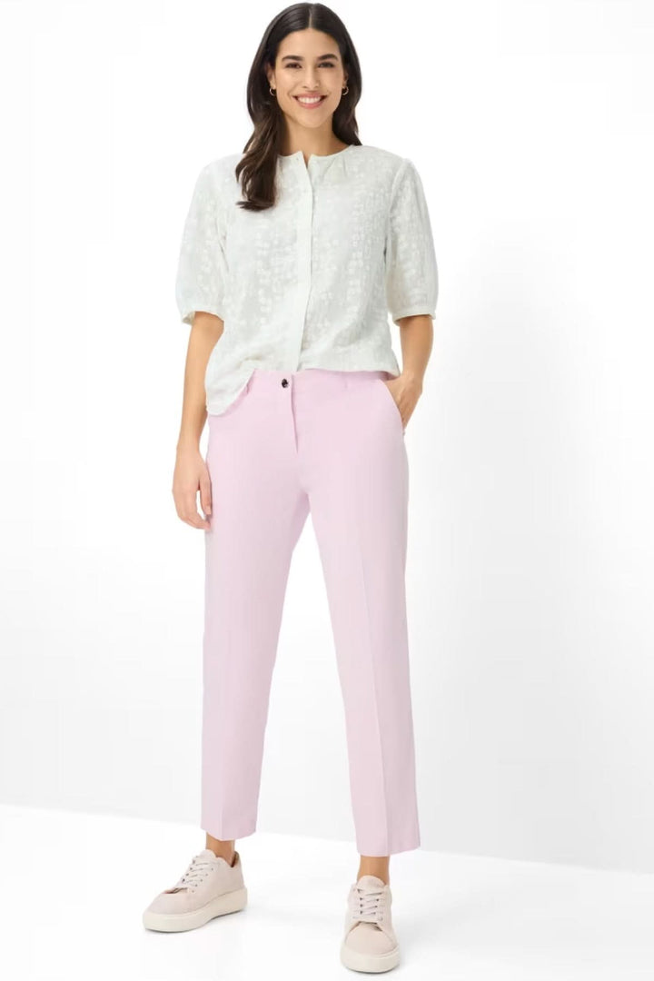 Femme portant un Pantalon Maron à coupe droite et longueur cheville, alliant confort et modernité en rose pastel, avec des poches pratiques.