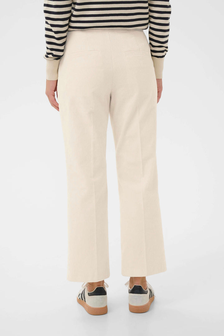 Pantalon Mishas en velours côtelé, coupe droite, couleur beige, vu de dos avec une tenue casual chic.