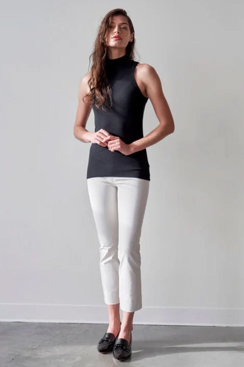 Femme portant le Pantalon Penny en blanc, coupe droite ajustée et longueur cheville, pour un style moderne et confortable.