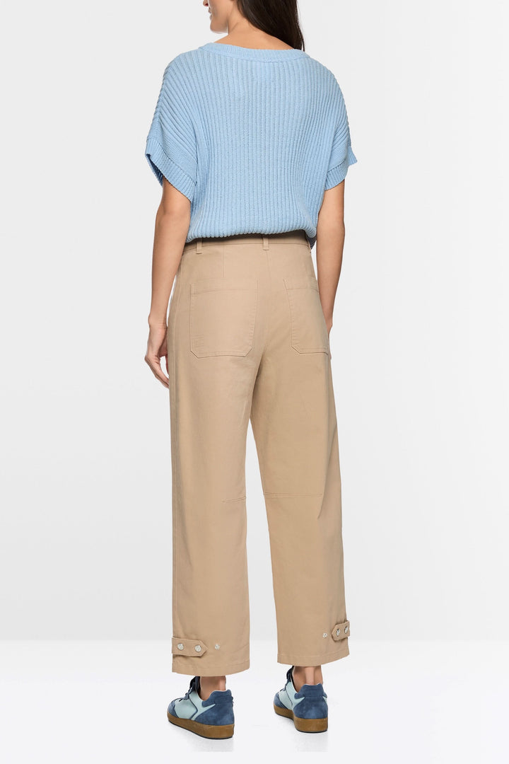 Femme portant le Pantalon RUMA en mélange de coton doux avec coupe droite ample, vu de dos, accentuant une silhouette moderne et structurée.