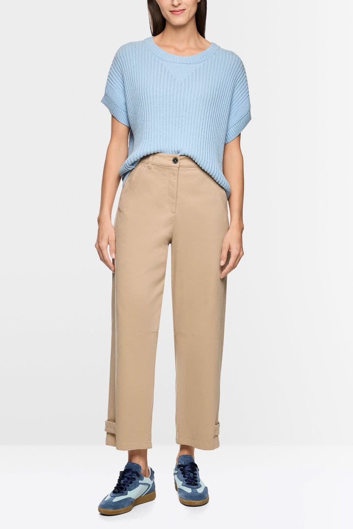 Pantalon RUMA en mélange de coton doux porté par un modèle, taille haute structurée, coupe droite et ample, longueur cheville, tenue moderne.