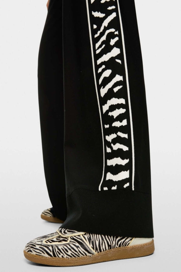 Pantalon WELKOM avec bande latérale imprimé animalier, coupe large et ourlet à bords-côtes, chaussure assortie, confort optimal.
