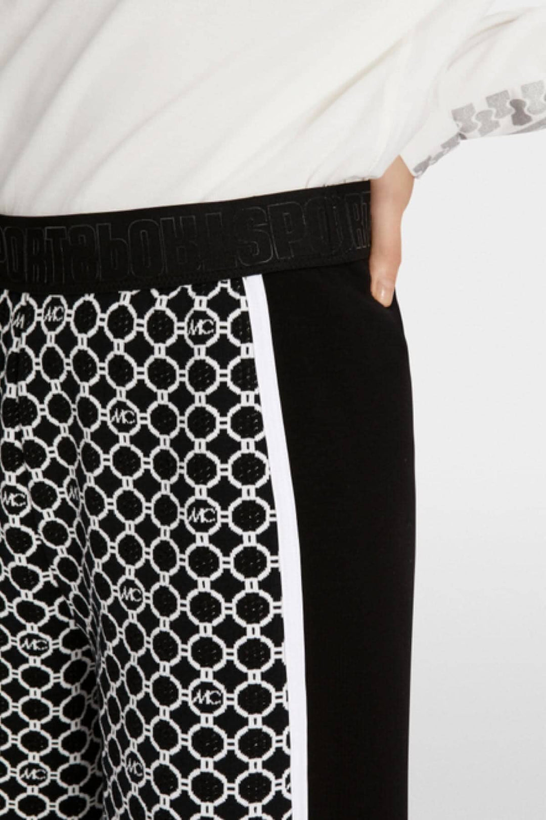 Détail du pantalon WUSU avec motif chaîne en tricot et ceinture élastique noire.