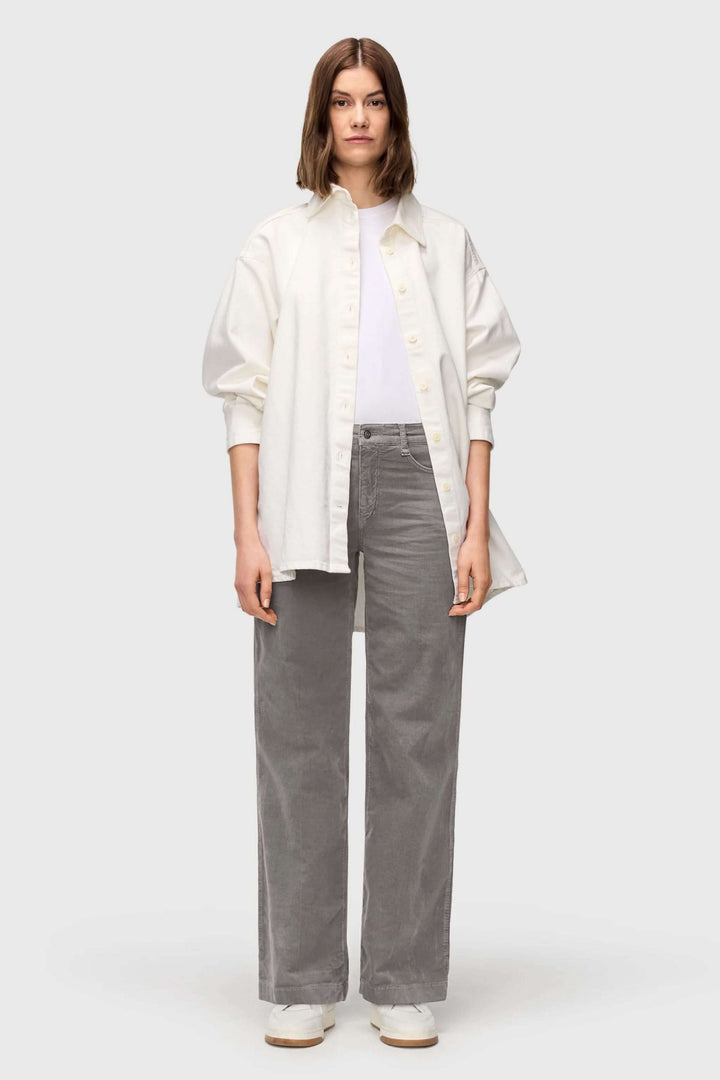 Femme portant un Pantalon Wide en velours côtelé à jambe large gris avec une chemise blanche, style automnal moderne et décontracté.