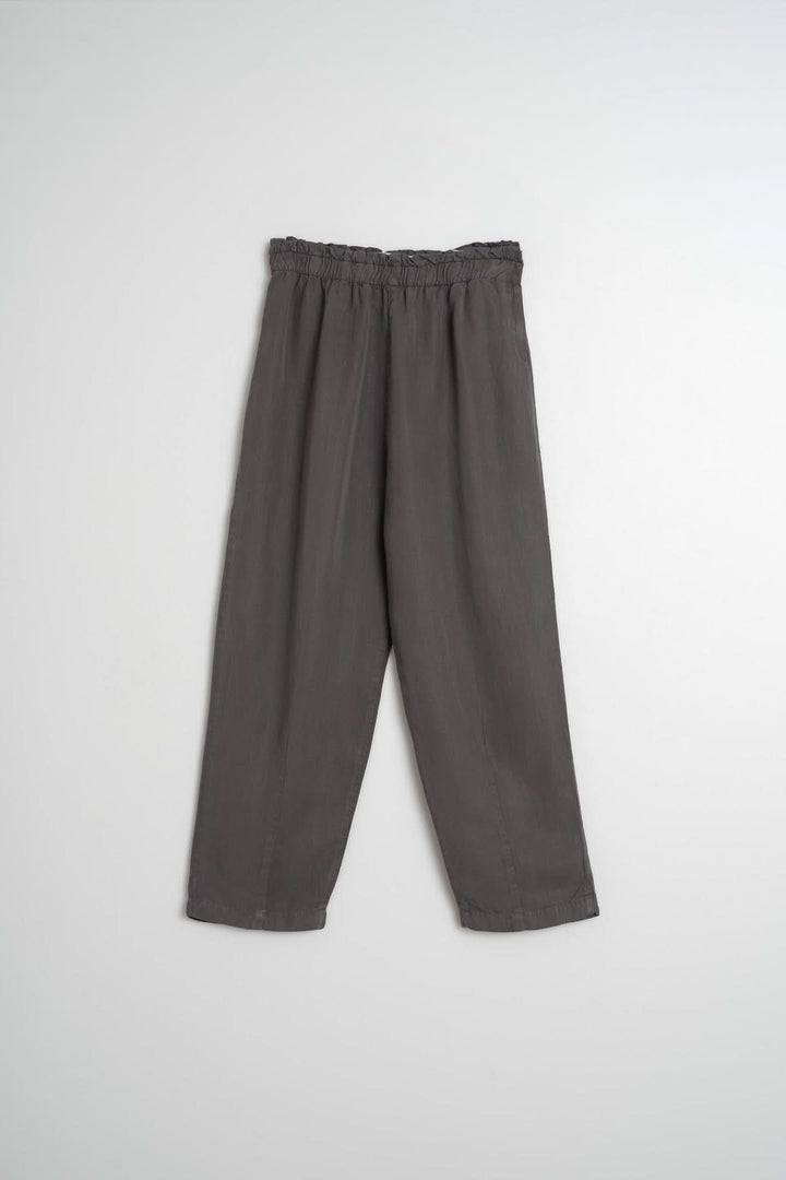Pantalon ample gris avec taille élastiquée, coupe fluide et longueur juste au-dessus des chevilles.