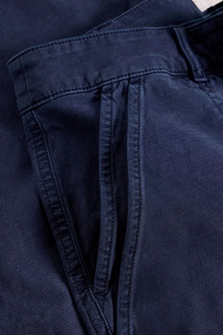 Détails d'un pantalon ample en tissu doux, mettant en avant la taille haute et la coupe fluide, couleur bleu marine.