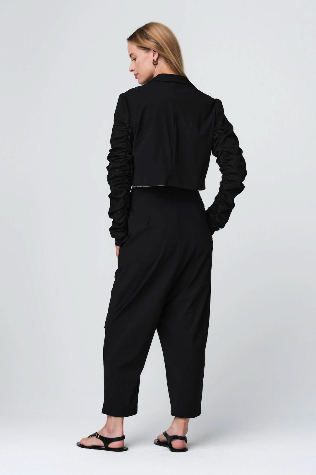 Woman wearing pantalon ample à taille structurée in black, showcasing fluid cut and contemporary style.
