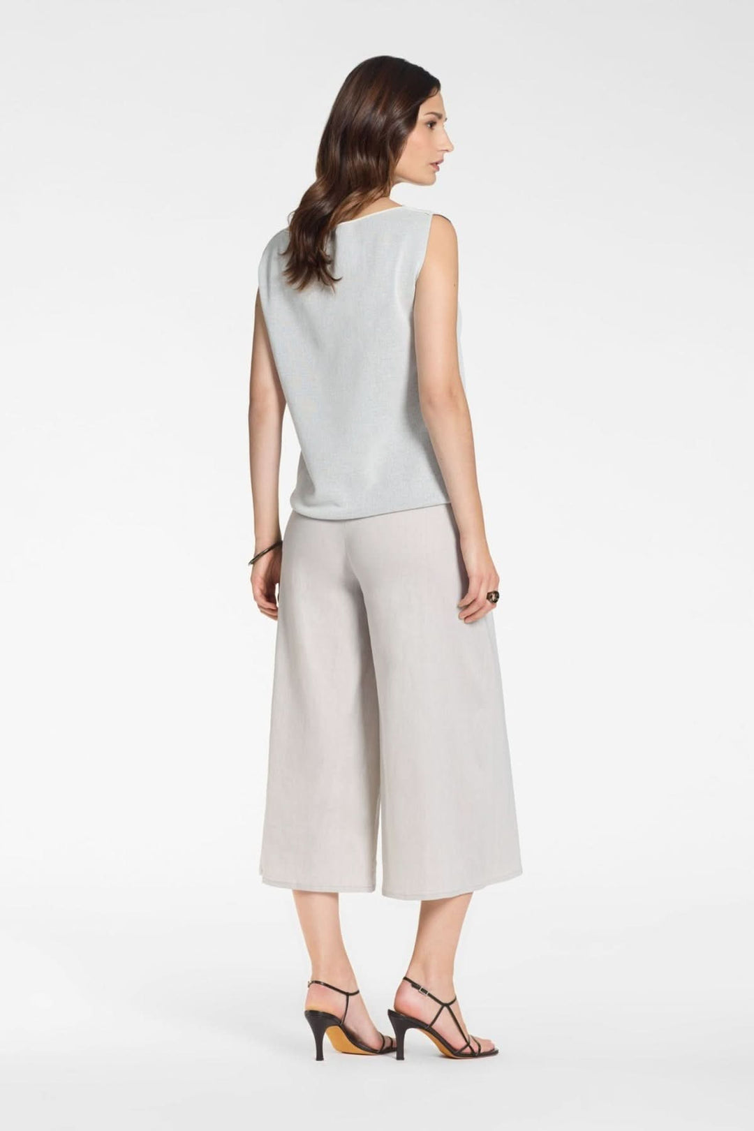 Femme portant un Pantalon asymétriquelarge à effet portefeuille, style élégant et moderne, coupe large et fluide, couleur grise.
