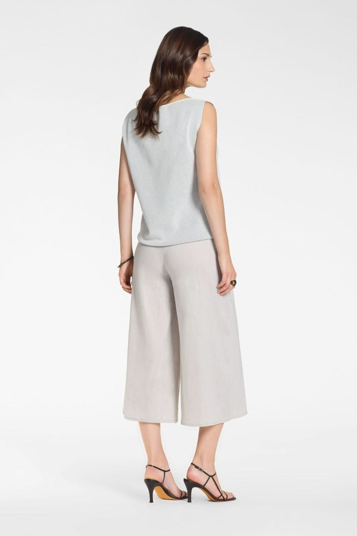 Femme portant un Pantalon asymétriquelarge à effet portefeuille, style élégant et moderne, coupe large et fluide, couleur grise.