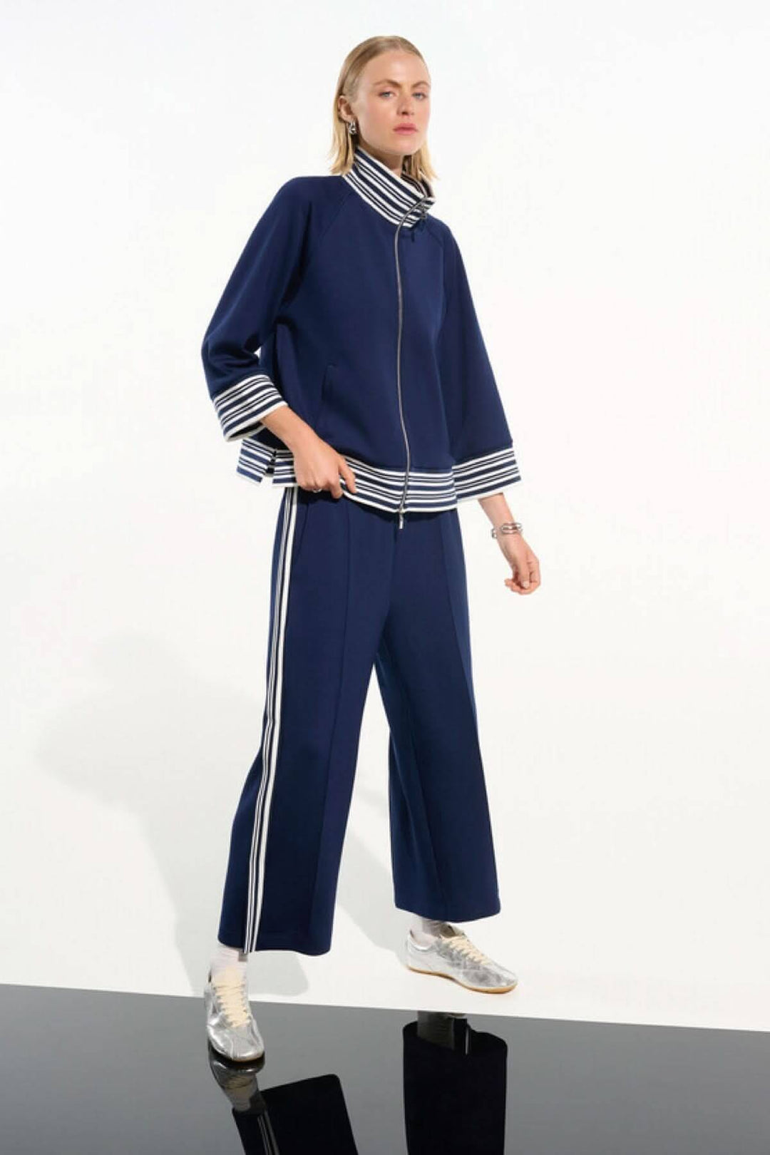 Pantalon athlétique à bandes contrastantes noué avec veste assortie, style sportif chic et moderne.