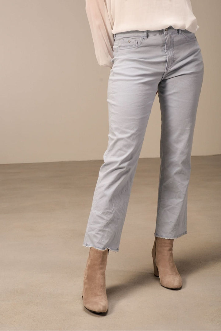 Pantalon bootcut bohème en coton bio, jambe évasée et bordure à franges, porté avec des bottines.