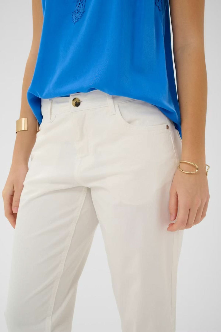 Femme portant un pantalon capri Berta coupe droite, mi-mollet, élégant et structuré, idéal pour un style décontracté ou soigné.