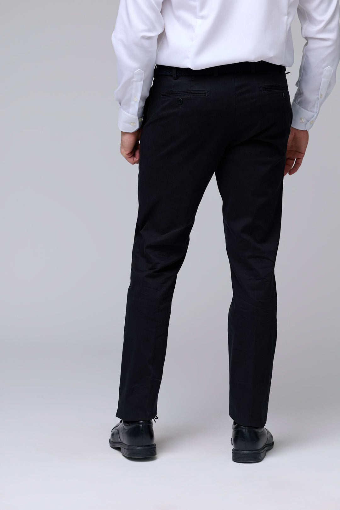 Pantalon chino ajusté noir pour homme avec coupe moderne et tissu extensible, vu de dos.