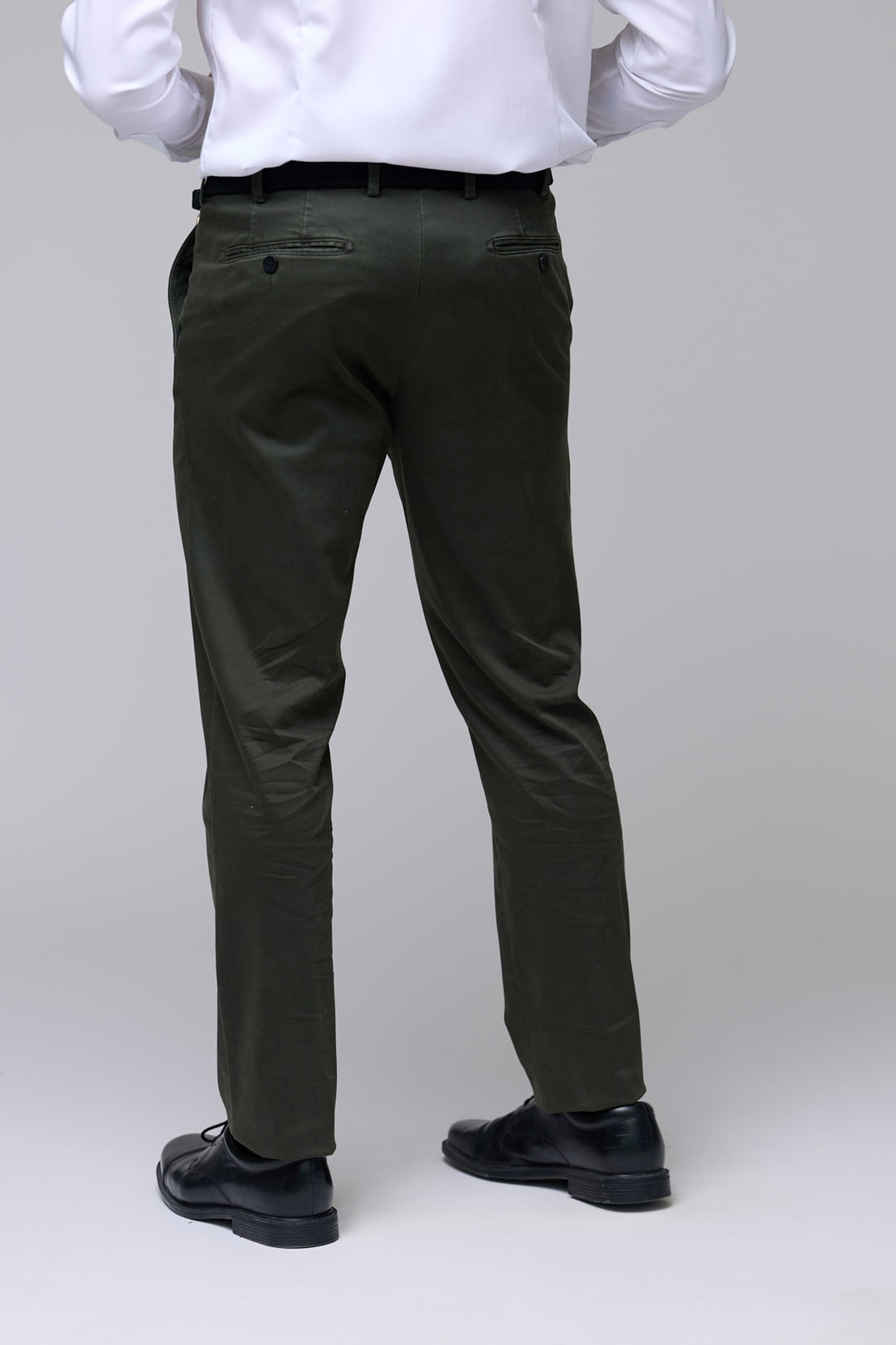 Homme portant pantalon chino ajusté vert foncé, coupe droite légèrement ajustée, parfait pour look professionnel et décontracté.