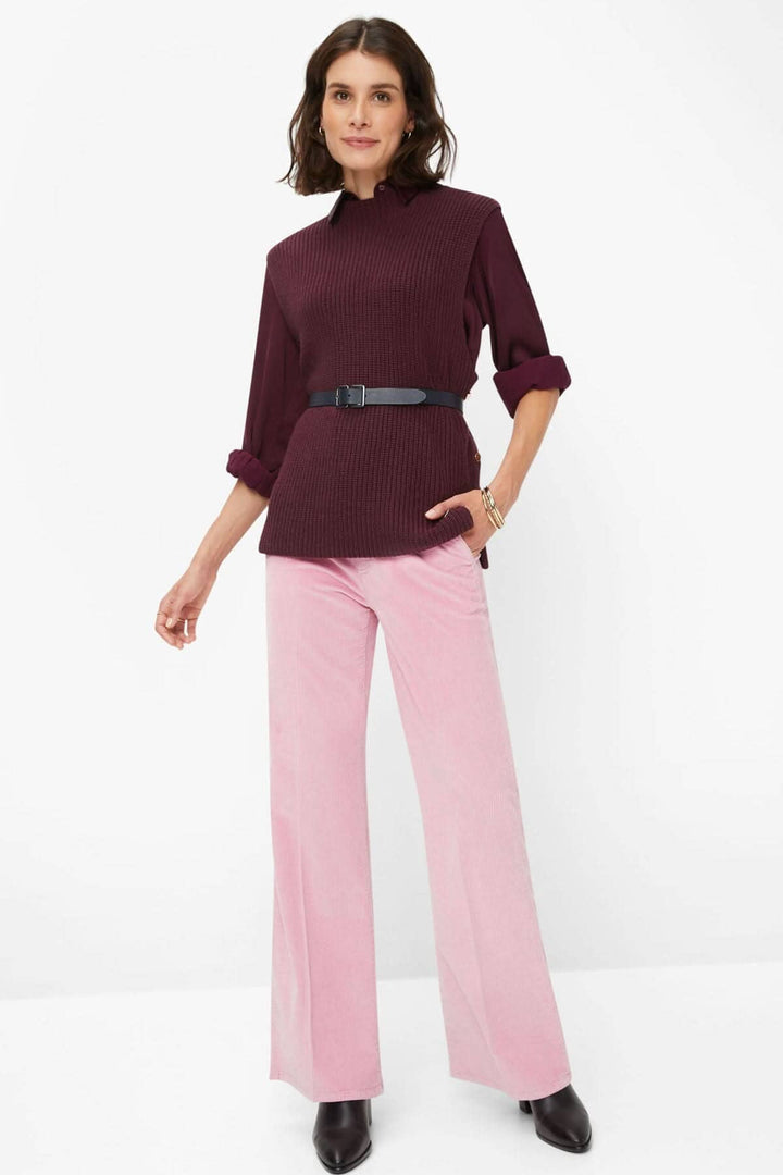 Femme portant un pantalon corduroy Maine rose avec un pull bordeaux cintré, montrant un look élégant et moderne.