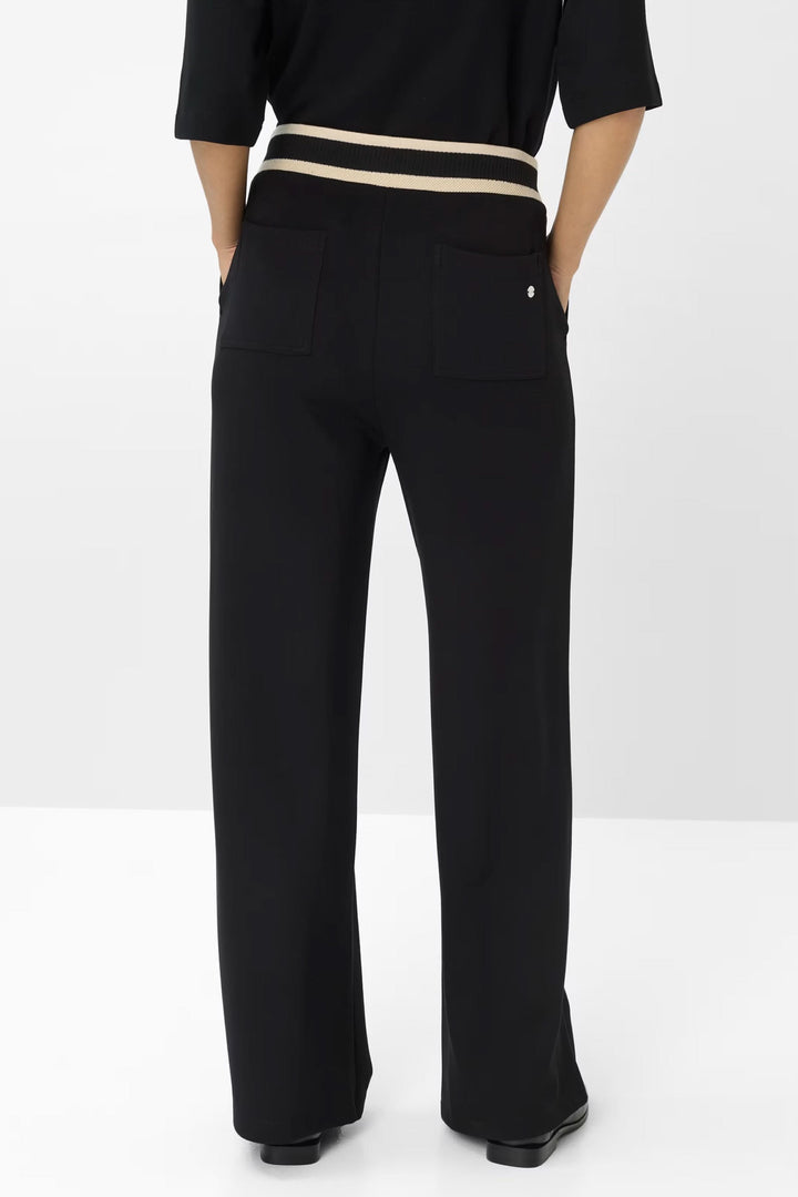 Pantalon noir coupe large avec ceinture élastiquée et détails contrastés au dos.
