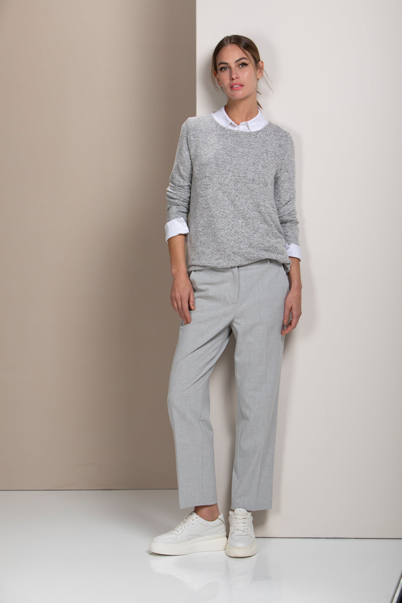 Femme portant un pantalon coupe droite gris, élégant et structuré, parfait pour le bureau ou quotidien, avec chemise et chandail gris.