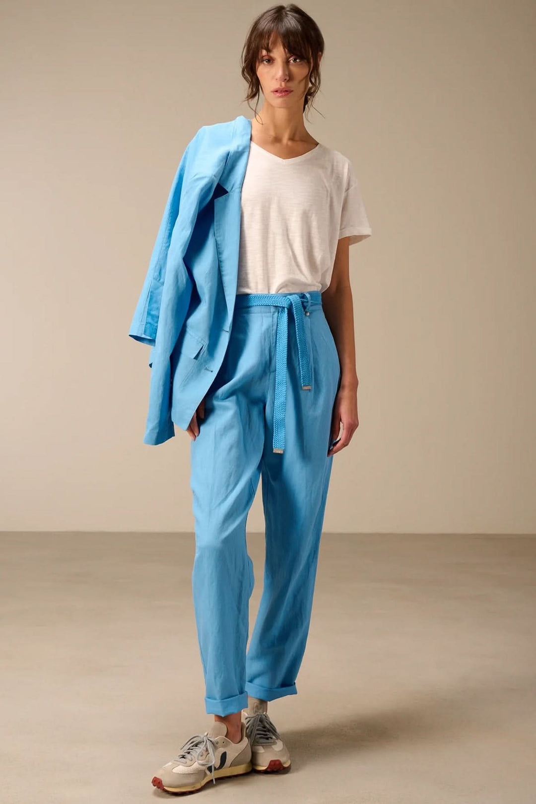 Femme portant un pantalon à coupe droite avec ceinture tressée, simple et élégant.