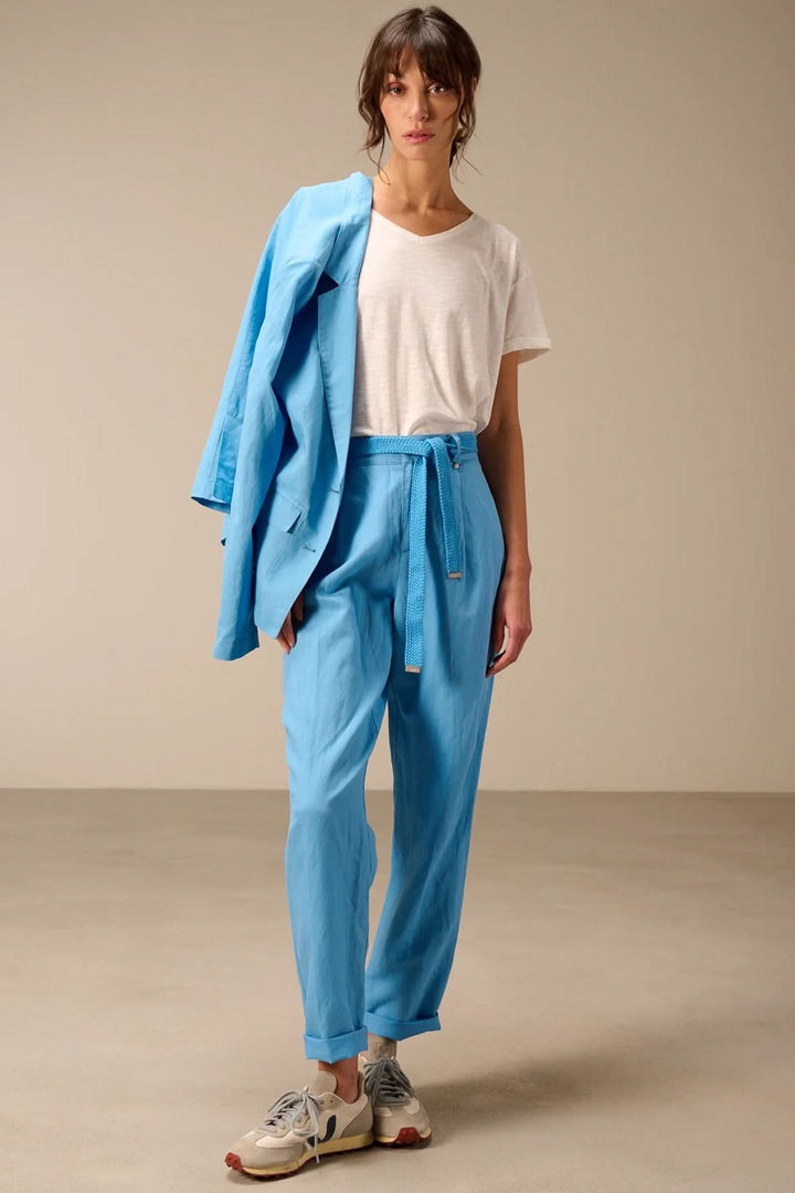 Femme portant un pantalon à coupe droite avec ceinture tressée, simple et élégant.