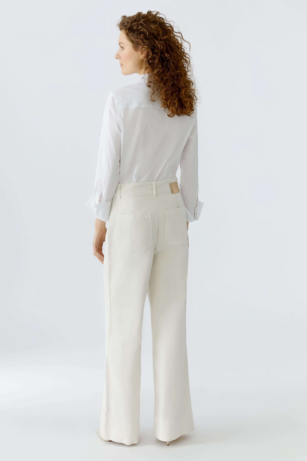 Pantalon droit à poches plaquées porté par une femme élégante, vue arrière, coupe structurée idéale pour le bureau ou le quotidien.