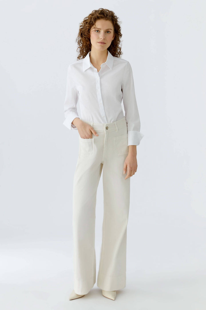 Femme portant un pantalon droit à poches plaquées, coupe élégante, tissu structuré, idéal pour le bureau ou le quotidien.