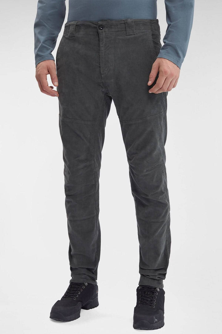Pantalon en velours côtelé noir, coupe ergonomique avec poches et braguette zippée, style moderne.