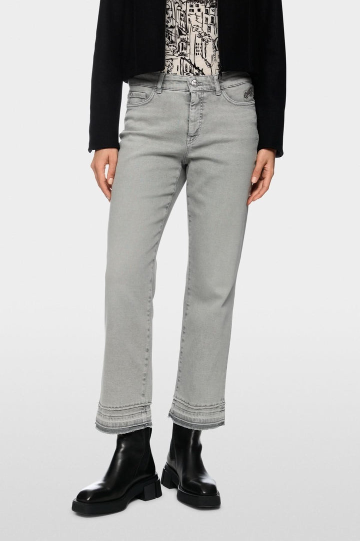 Pantalon en denim moderne avec coupe droite évasée et bas effiloché, idéal pour un style décontracté et contemporain.