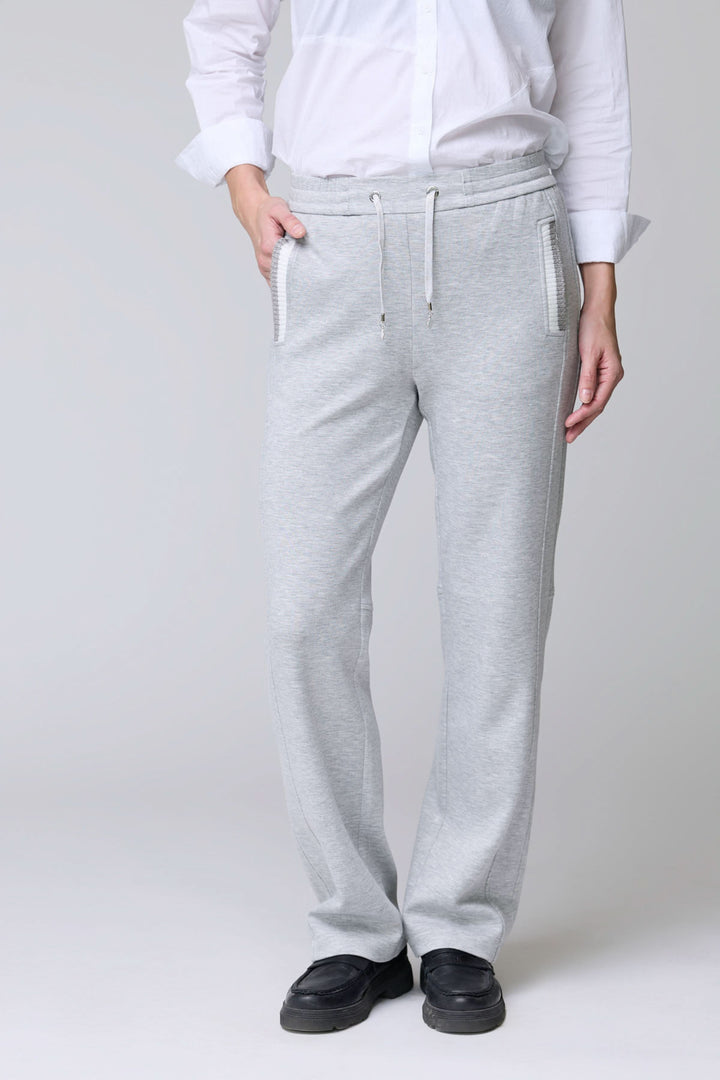 Homme portant un pantalon en jersey ajustable gris avec cordon et poches, idéal pour confort et élégance décontractée.