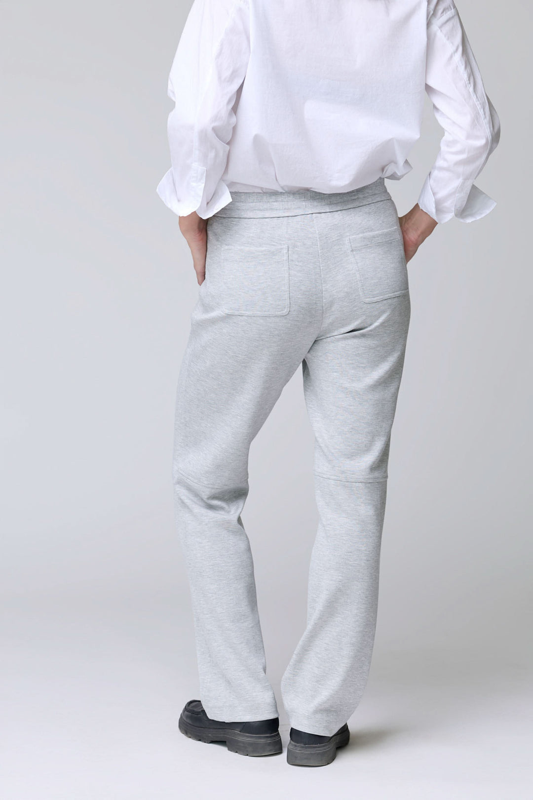 Homme portant un pantalon en jersey ajustable gris avec poches arrière, parfait pour un look décontracté et confortable.