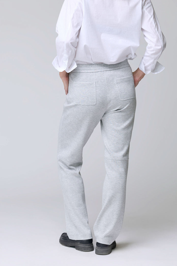 Homme portant un pantalon en jersey ajustable gris avec poches arrière, parfait pour un look décontracté et confortable.
