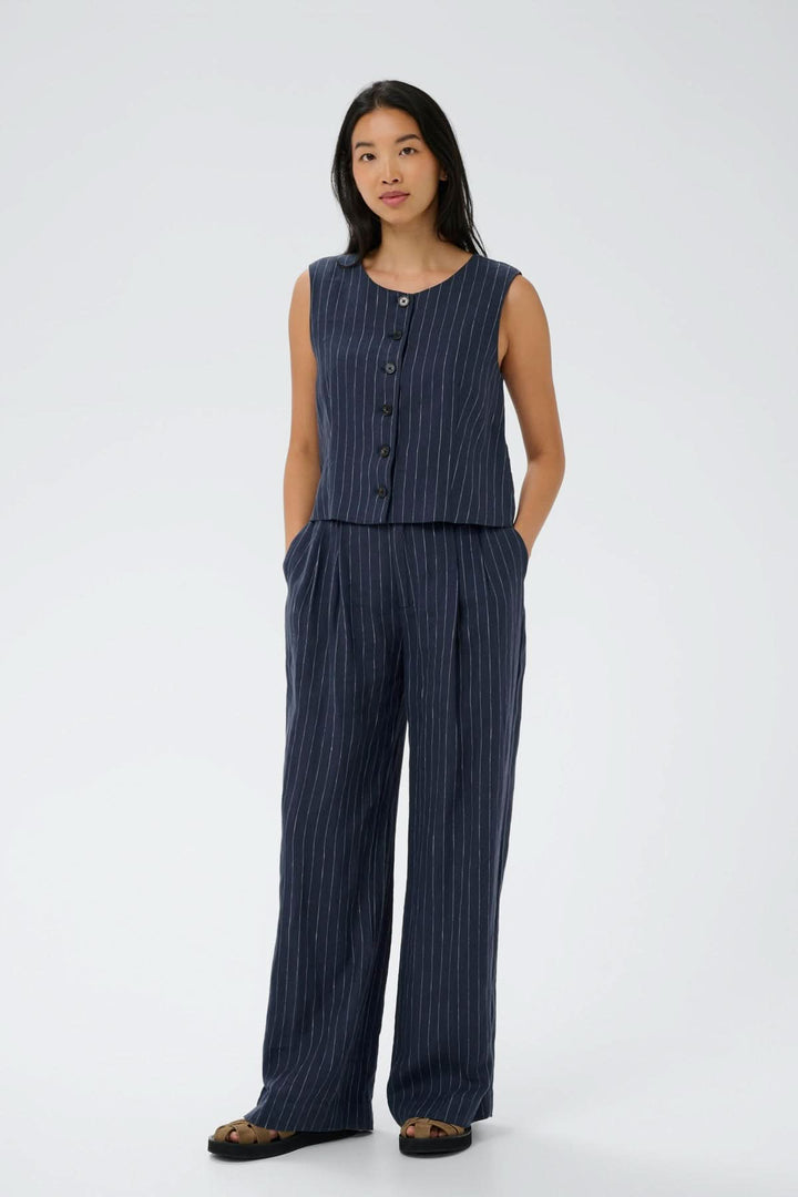 Modèle portant le pantalon en lin Aliya avec un haut assorti, créant une allure fluide et élégante idéale pour la saison chaude.