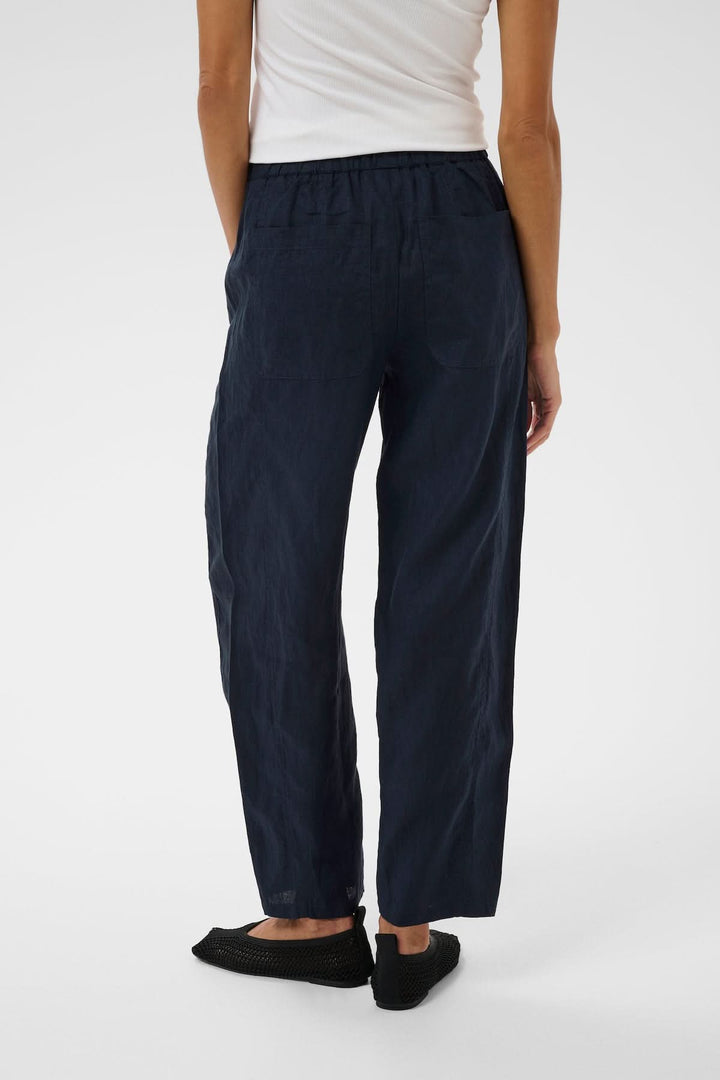 Vue arrière du Pantalon en lin Atima bleu foncé avec coupe droite, porté par un mannequin, soulignant son style épuré et confortable.