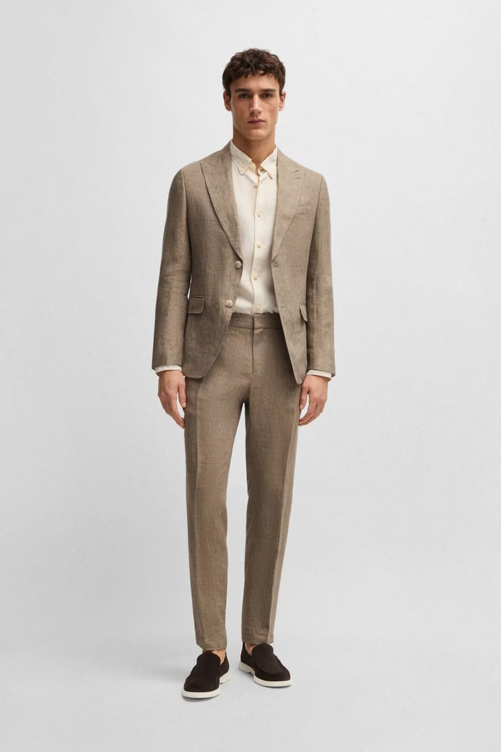 Homme en pantalon en lin élégant, tenue moderne et décontractée, avec blazer beige, chaussures noires.