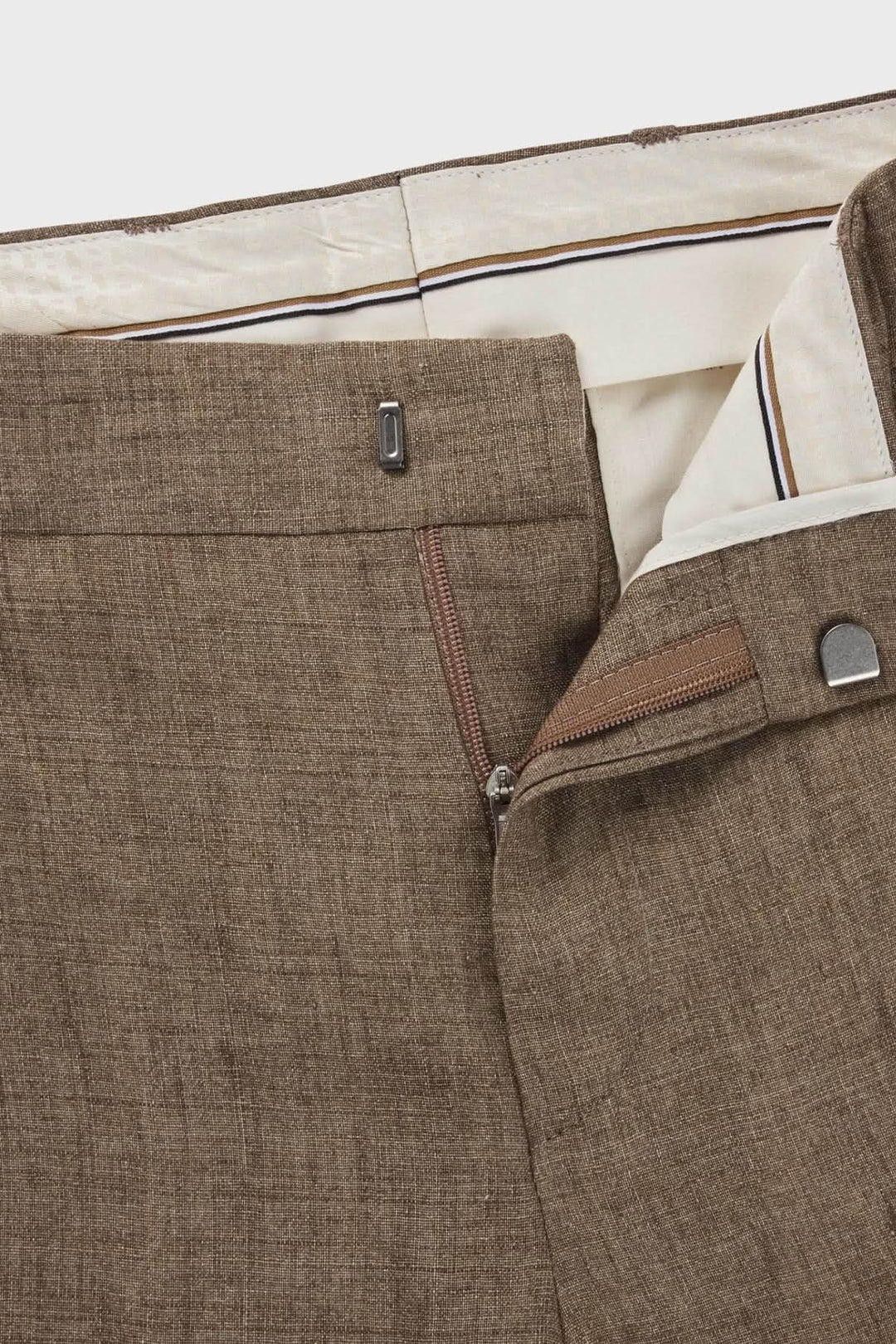 Détails du pantalon en lin, montrant la doublure intérieure et la fermeture à glissière en bronze.