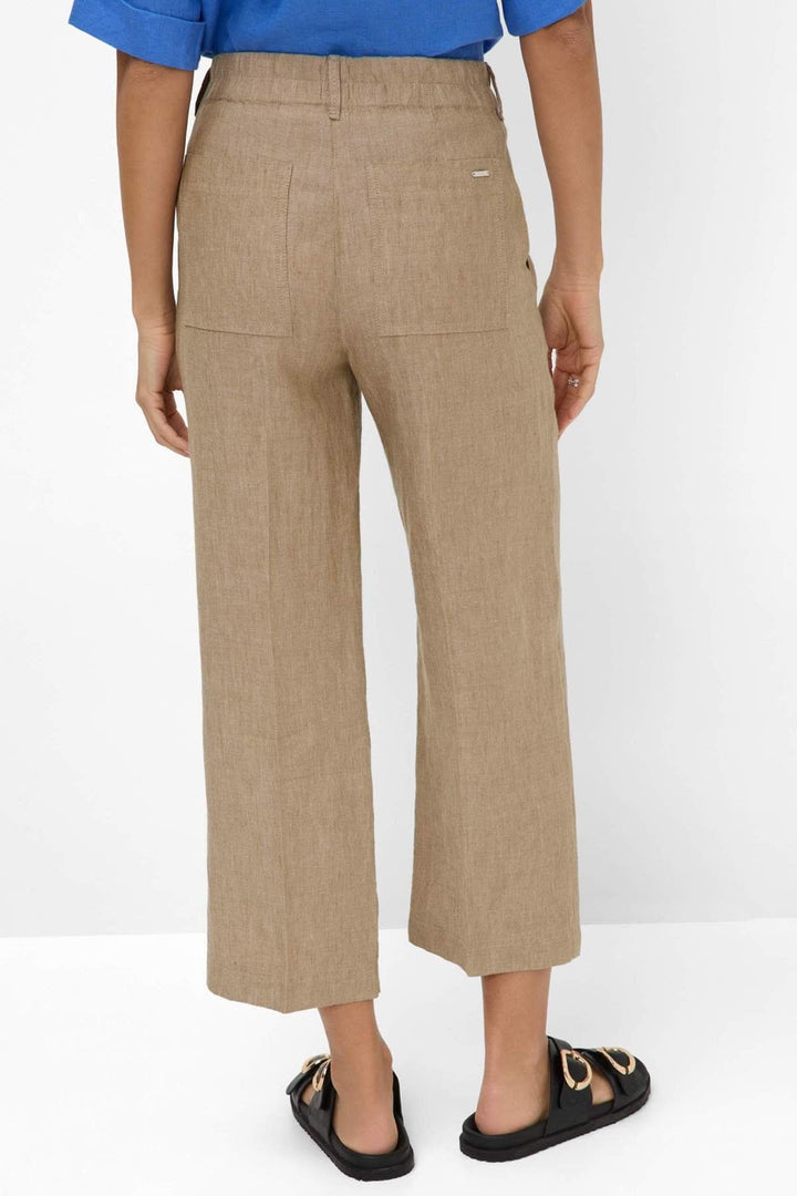 Dos du mannequin portant un Pantalon en lin MAINE S, large et écourté, en tissu naturel, parfait pour l'été et le confort quotidien.