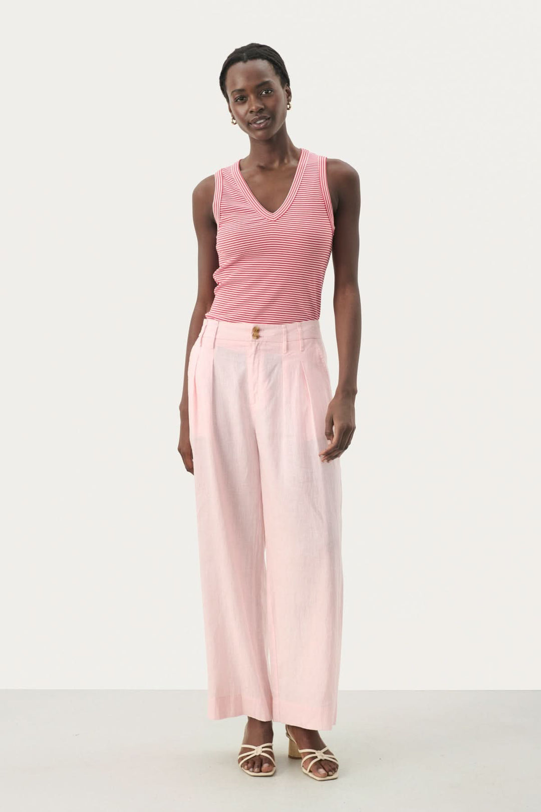Femme portant un pantalon en lin Nanati à jambes larges, avec un top rose, style décontracté.